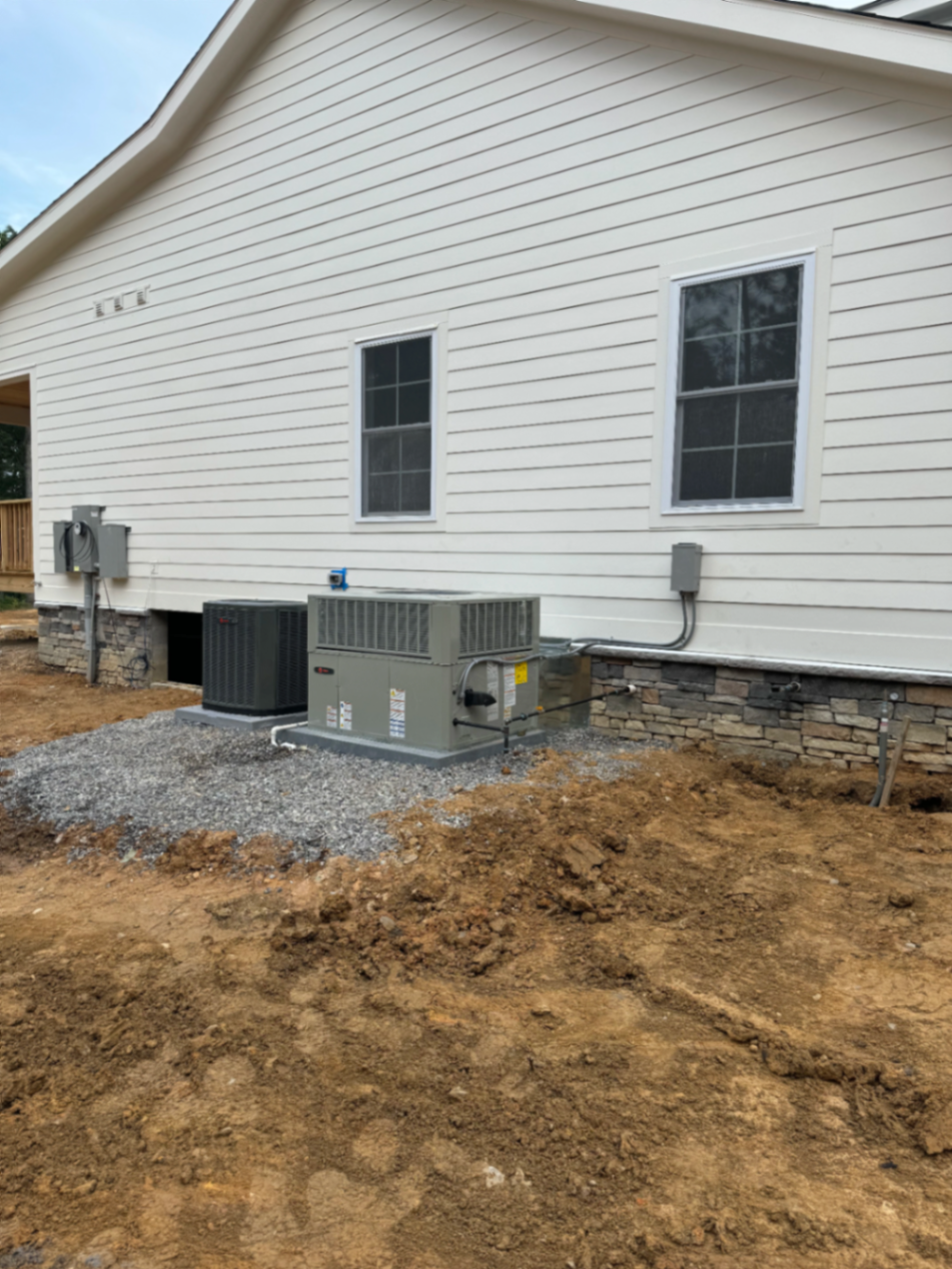 New construction home with package HVAC equipment installed along the side yard