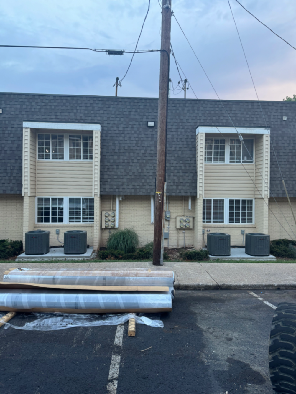 Multiple outdoor HVAC condenser units installed along a townhouse building