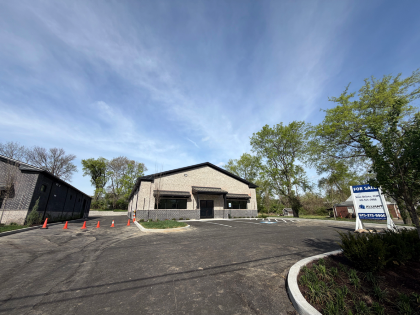 Finished commercial building exterior after HVAC installation with fresh parking lot and landscaped frontage